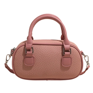 Pink lychee texture leather bowling bag with dual handles and crossbody strap