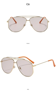Detail view of gold aviator sunglasses with lilac lenses and orange temple tips