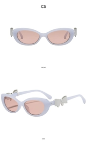 Détail de lunettes œil-de-chat lilas avec verres roses et nœud 3D sur le côté