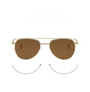 Detail of aviator sunglasses featuring a gold metal double-bridge frame and brown lenses