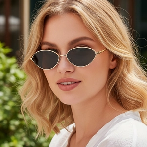 Retro oval sunglasses with slim gold metal frames and dark lenses worn by a model