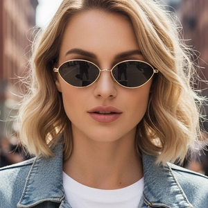 Close-up of golden oval sunglasses on model with black lenses and slim metal frames