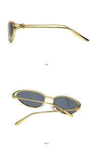 Detail view of gold metal sunglasses with side twist design and dark gray lenses