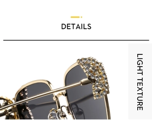 Close-up of golden metal sunglasses frame with rhinestone letter D and grey lenses