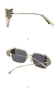 Detail of golden metal frame sunglasses with butterfly rhinestone hinge and gray lenses