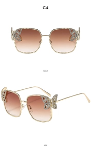 Detail of square metal sunglasses featuring crystal butterfly accents and brown lenses