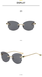 Detail of rimless grey wavy lenses with gold temples and decorative insect accents