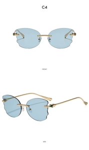 Detail view of cloud-shaped blue rimless sunglasses with gold metal frame and green beads