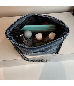 Spacious interior of denim tote bag showing storage for tablet and umbrella