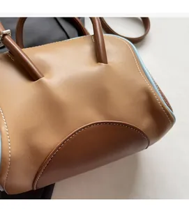 Detalle de las costuras de cuero en dos tonos y pintura de borde azul en un bolso