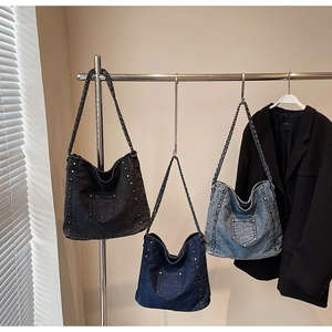 Detailed view of denim crossbody bags in three washes with metallic stud accents