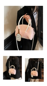 Vistas de un bolso bowling rosa y blanco con correa ajustable y un colgante divertido