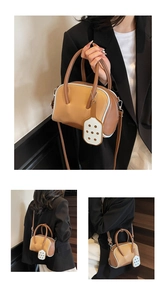 Detalle de bolso bowling bicolor con paneles marrones y beige y correa bandolera