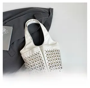 Close-up of ivory punk tote bag featuring silver rivet studs on front pockets