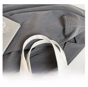 Close-up of the smooth white PU leather handle on a fashionable rivet shoulder bag