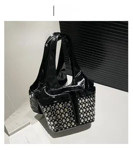 Detail of black patent leather bag with silver studs and two large functional front pockets