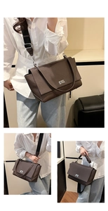 Detail of dark brown pebble leather bag with silver twist lock and wide fabric strap