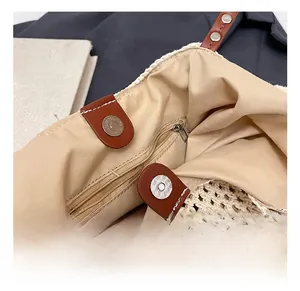 Close-up of woven tote bag interior with magnetic snap closure and leather strap details