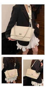 Detail of off-white lychee texture leather bag with metal turn-lock and wide shoulder strap