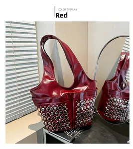 Detail view of red patent leather punk tote bag with silver studs and mirror reflection