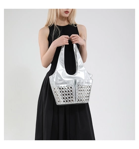 Detail of silver metallic punk tote bag with industrial rivet hole design and wide handle