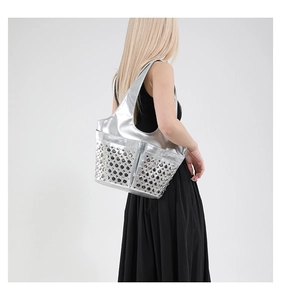 Silver metallic tote bag with hollow-out design shown on model for fashion styling