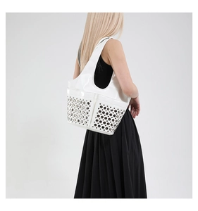 Detail of white patent leather shoulder bag with silver stud rivets on the side and pocket