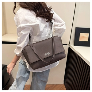 Detail view of a large dark leather shoulder bag with silver metal swivel lock and strap