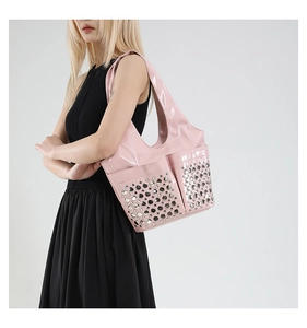 Detail of pink patent leather tote featuring metallic silver stud rivets on front pockets