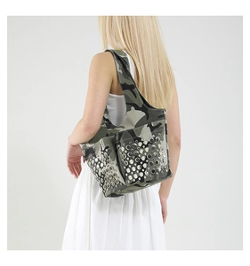 Detail of camouflage tote bag with silver metal studs shown on a model
