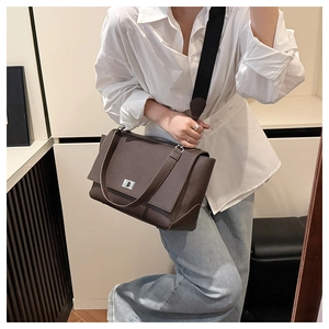 Detail of dark brown pebble leather bag featuring silver twist-lock and stitching