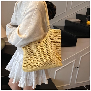 Detail of yellow woven tote bag with white leather strap and rivet reinforcements