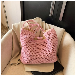 Detail of pink crochet tote bag with synthetic leather handles and metal rivets