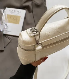 Top detail of cream quilted handbag with silver hardware and textured rhombic pattern