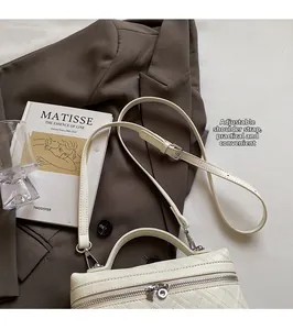 Detail of beige quilted crossbody bag with adjustable strap and silver zippers