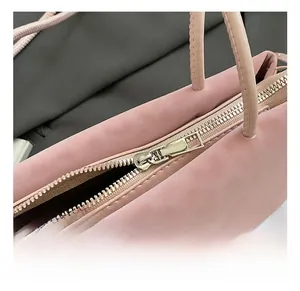 Close-up of premium light gold zipper hardware on a pink smooth leather handbag detail