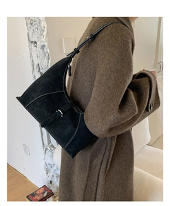 Detail of black crescent hobo bag with white stitching and metallic buckle details