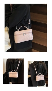 Detail of pink quilted rectangular handbag featuring silver zipper and leather texture