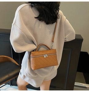 Detail of vintage brown textured leather handbag with silver zippers and top handle