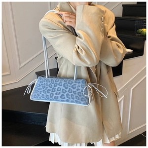 Close-up of blue leopard print shoulder bag featuring delicate side bow knot details