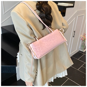 Detailed view of pink leopard print shoulder bag with decorative side ribbon bow