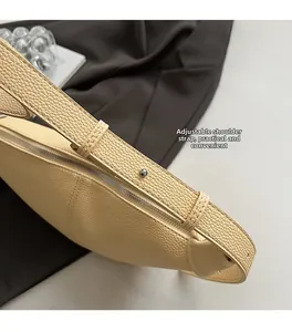 Detail of adjustable shoulder strap with metal studs on yellow lychee leather bag