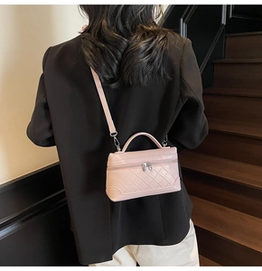 Pink quilted PU leather crossbody bag worn over a black blazer for a stylish look