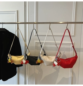 Detail view of crescent shoulder bags in four colors with elephant and heart charms