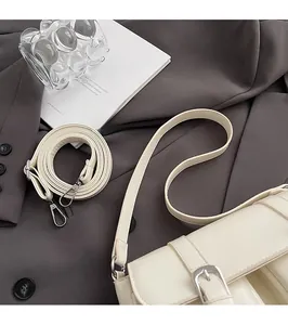 Close-up of cream white retro shoulder bag with silver metal hooks on a blazer