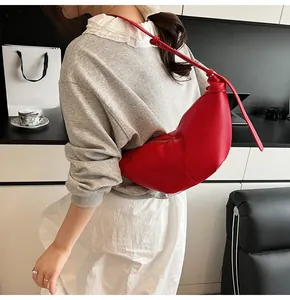 Detail of red hobo bag with lychee texture and adjustable knotted shoulder strap