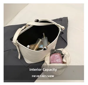 Capacité interne du sac seau en cuir grainé blanc avec maquillage et portefeuille