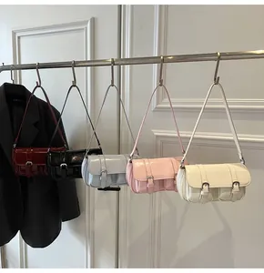 Gros plan de cinq sacs baguette colorés en cuir verni brillant avec boucles métalliques