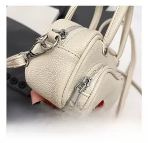 Close-up of creamy pebble-grain leather texture with polished silver metal zippers