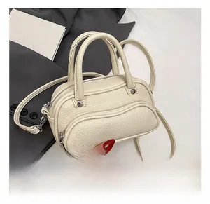 Detailed macro view of cream litchi texture leather handbag with silver hardware and pockets